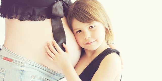 child hugging pregnant mother