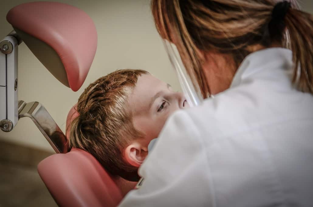 Woman checking the child's teeth